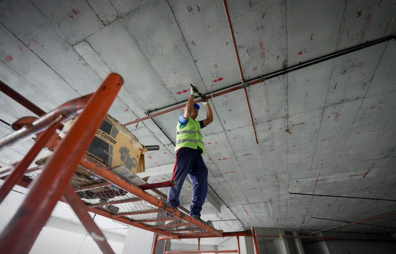 a man standing on a ladder working on a ceiling