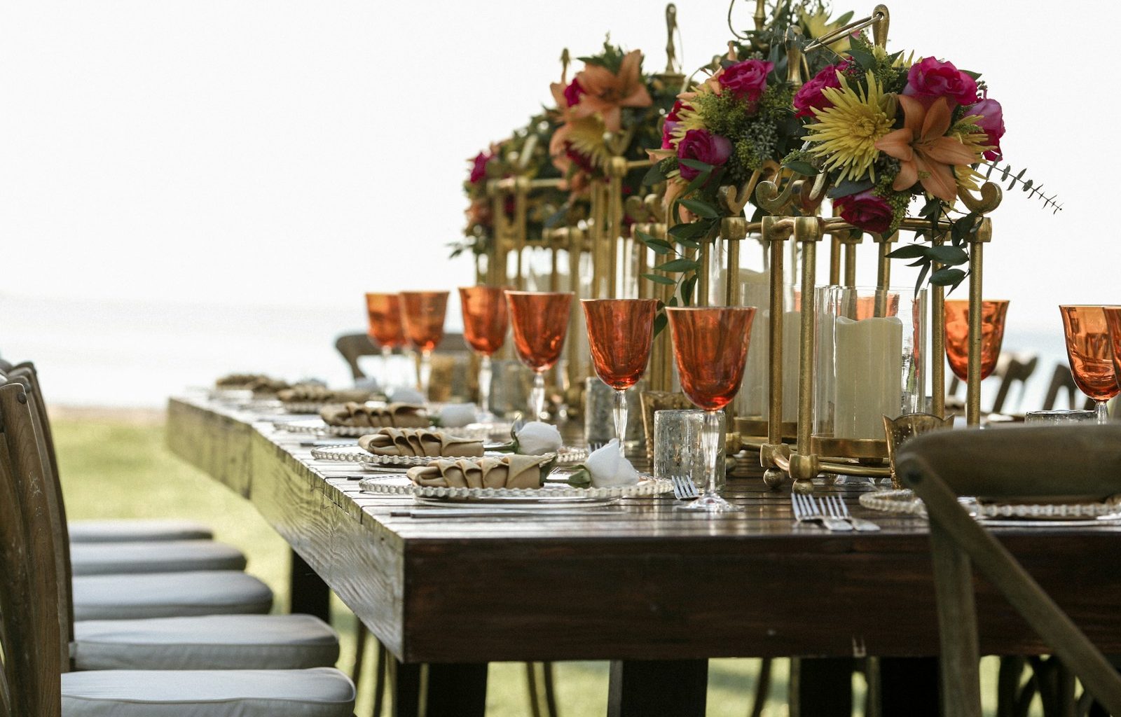 orange tinted wine glasses on rectangular brown wooden dining table