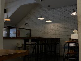 a room with a brick wall and several stools