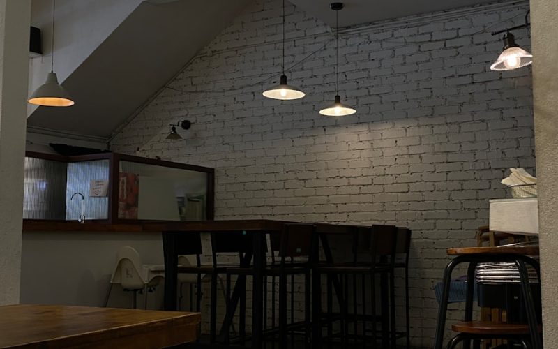 a room with a brick wall and several stools