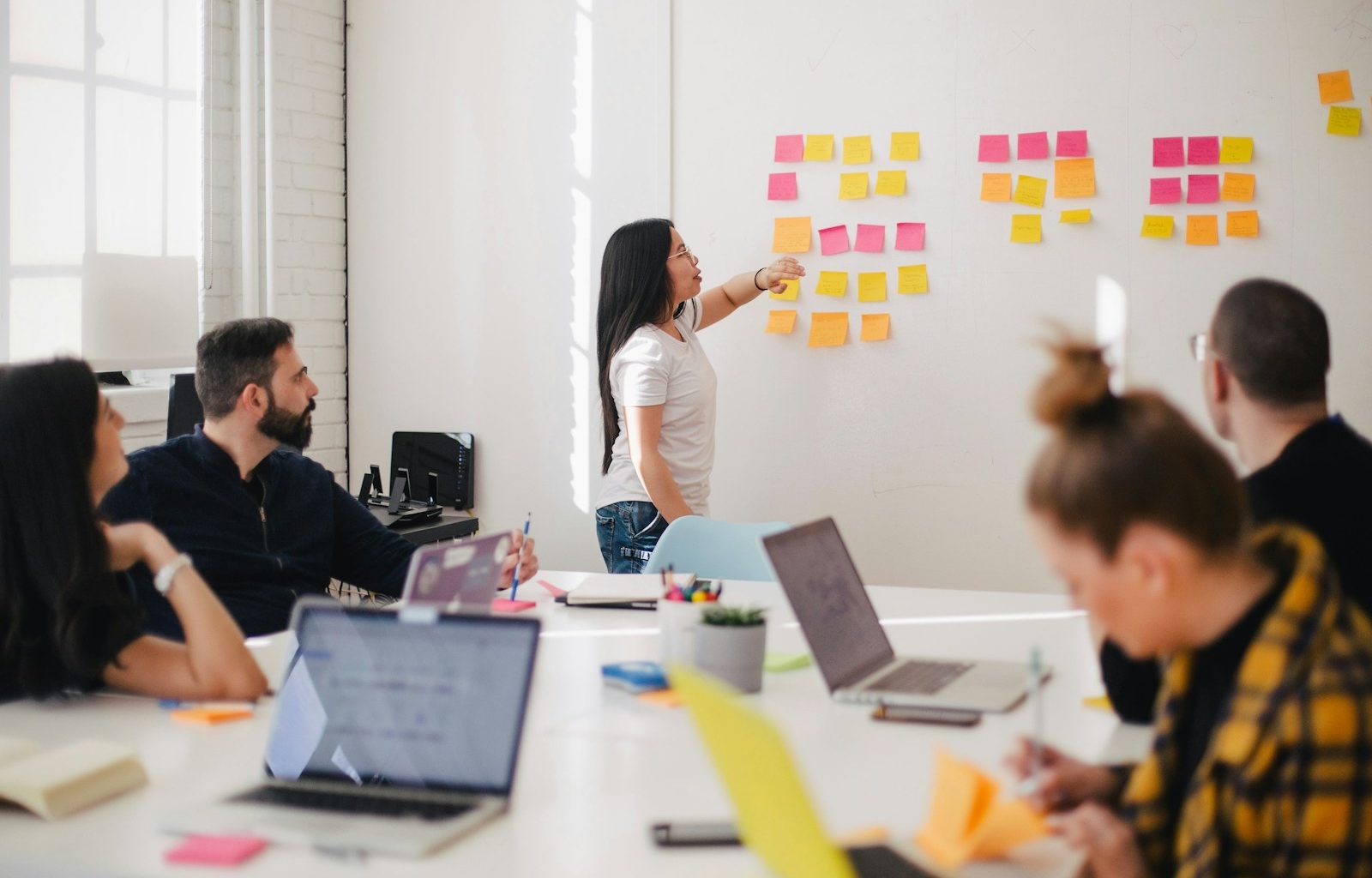 woman placing sticky notes on wall