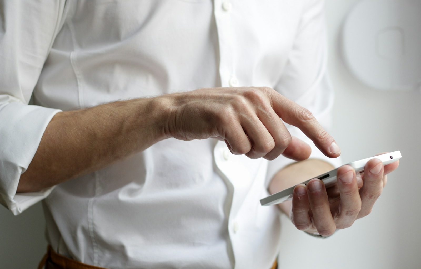 person holding white Android smartphone in white shirt