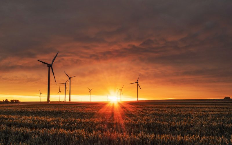 windmill on grass field during golden hour