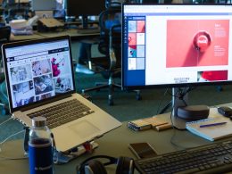 a desk with computers and a laptop