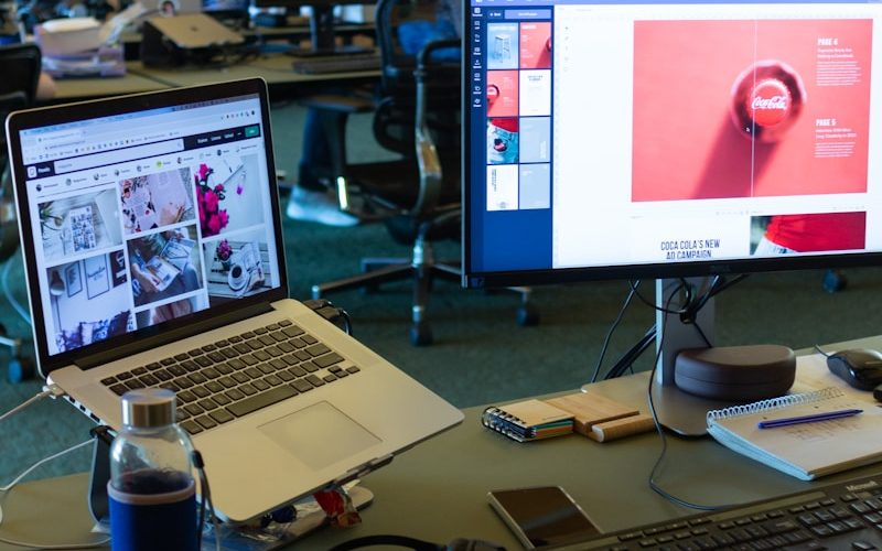 a desk with computers and a laptop