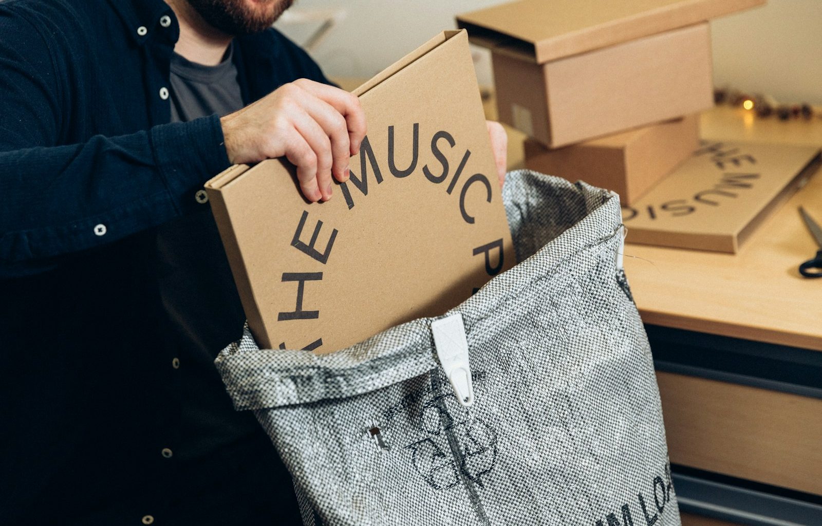 man in black jacket holding brown cardboard box