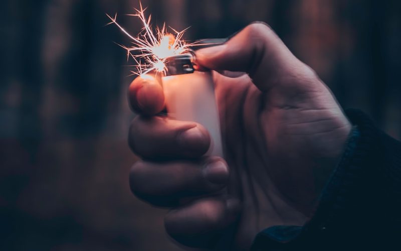 person using white disposable lighter