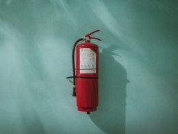 red fire extinguisher on green wall