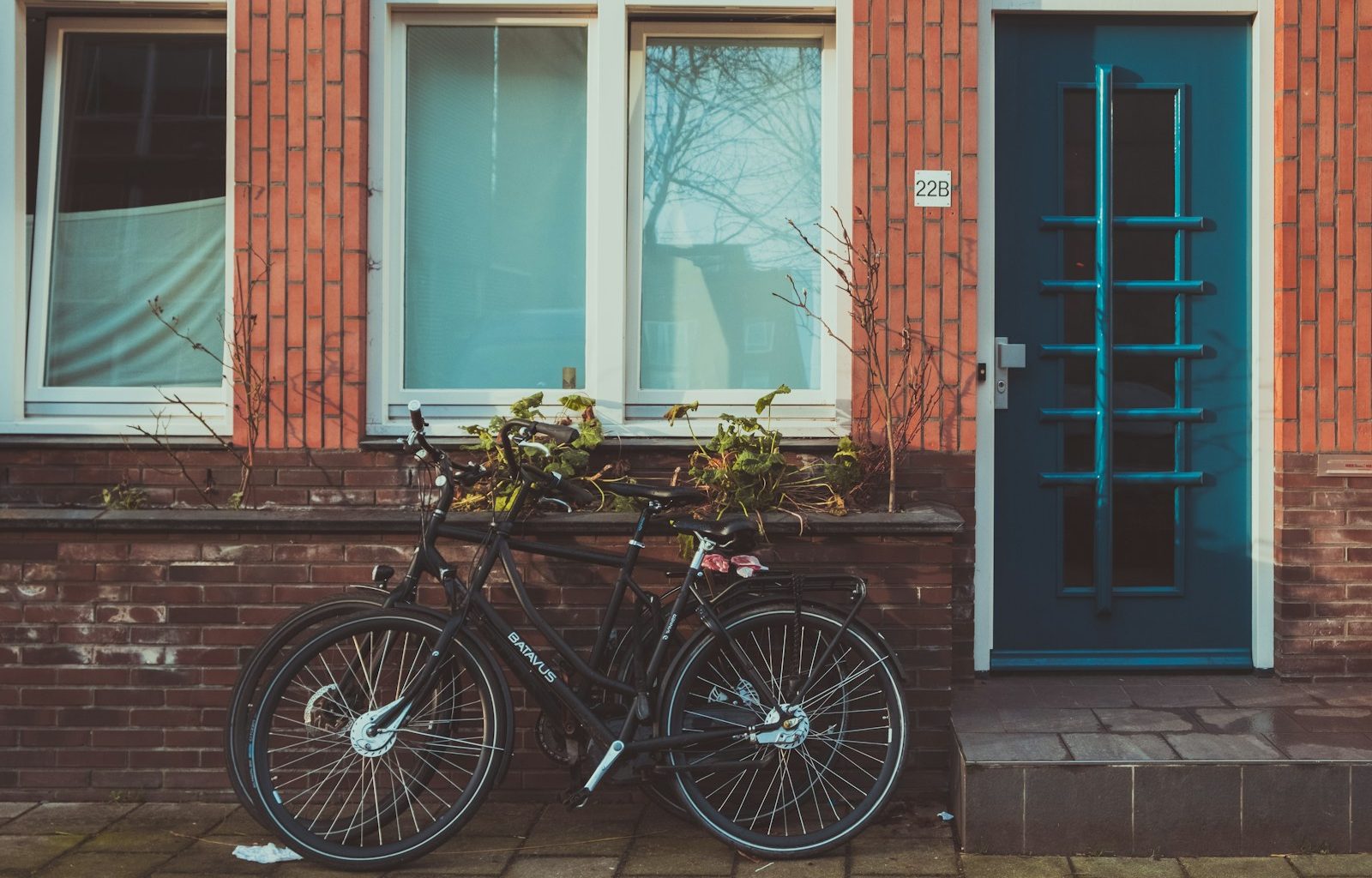 black road bicycles beside brown concrete wall during daytime