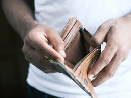 person holding brown leather bifold wallet